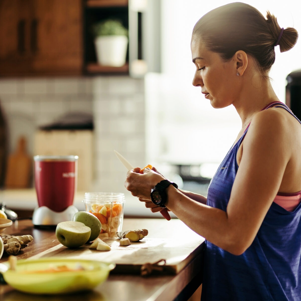 Femme en tenue de sport préparant son petit déjeuner dans la cuisine
